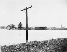 [Photo: Looking east from the railroad tracks at Rose Avenue; St. John’s Church steeple at far right]